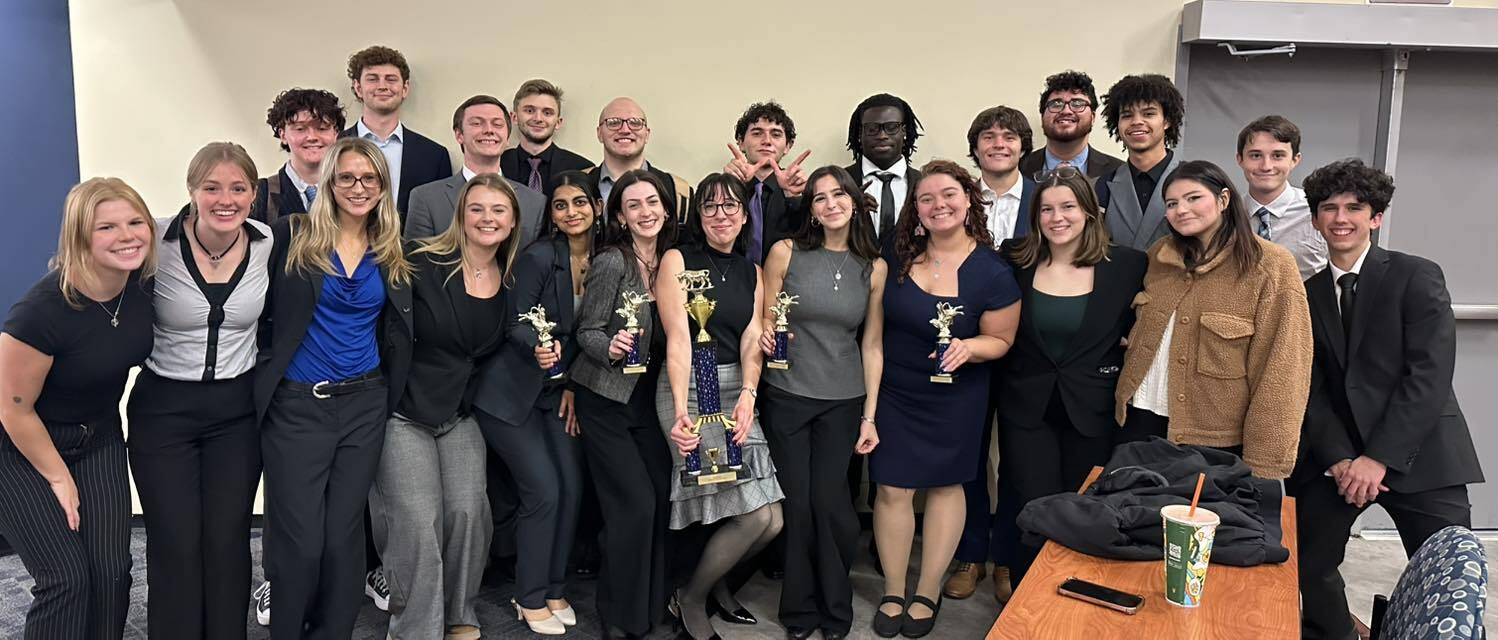 A group of students pose with trophies