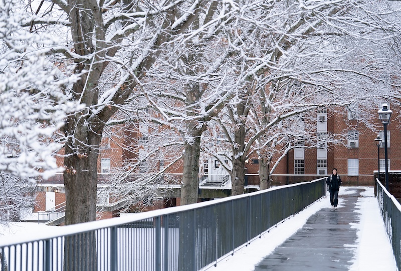 A student walks across campus in the snow