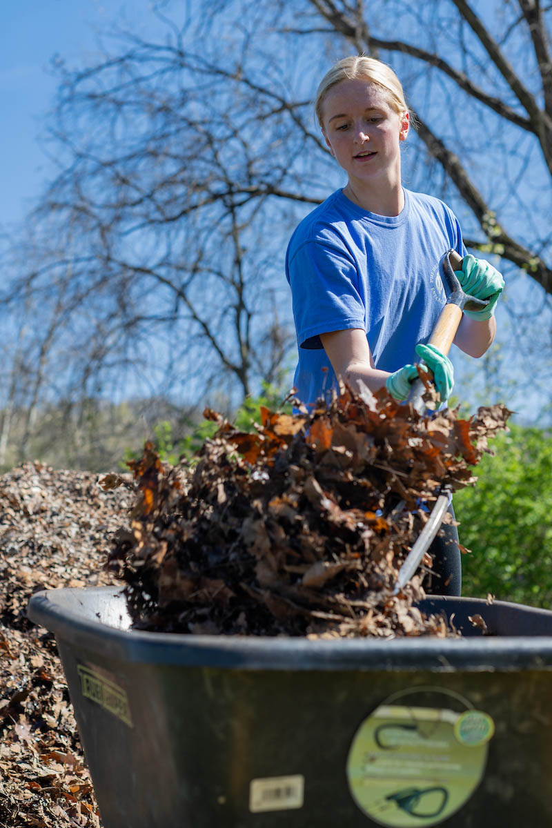 A student works at a community garden. 