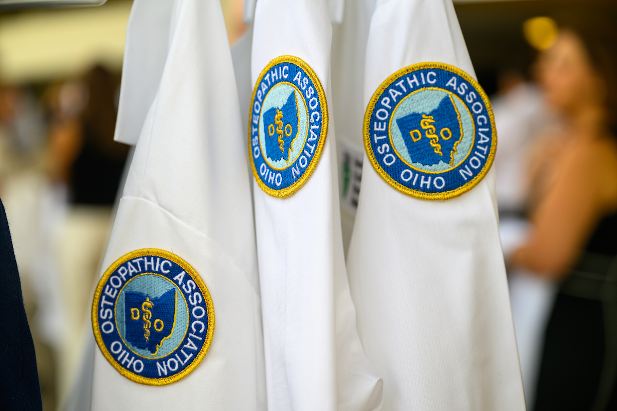 Heritage College of Osteopathic Medicine coats are shown with the OHIO Osteopathic Association logo on the sleeves