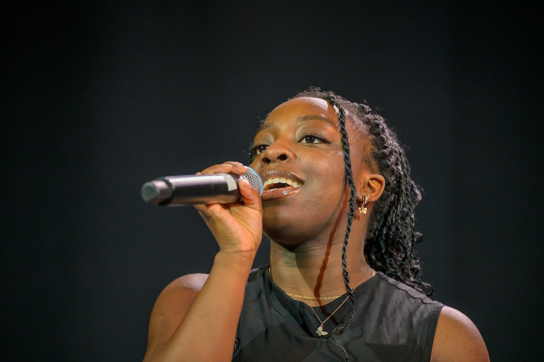 A woman sings into a microphone 