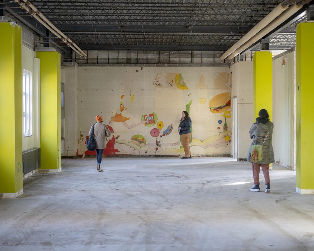 Visitors are standing in front of a recently uncovered mural