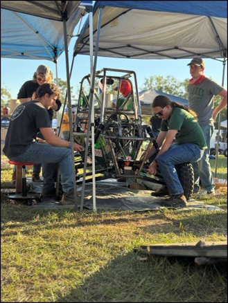 A group of team members making adjustments and repairs to Boyler. 