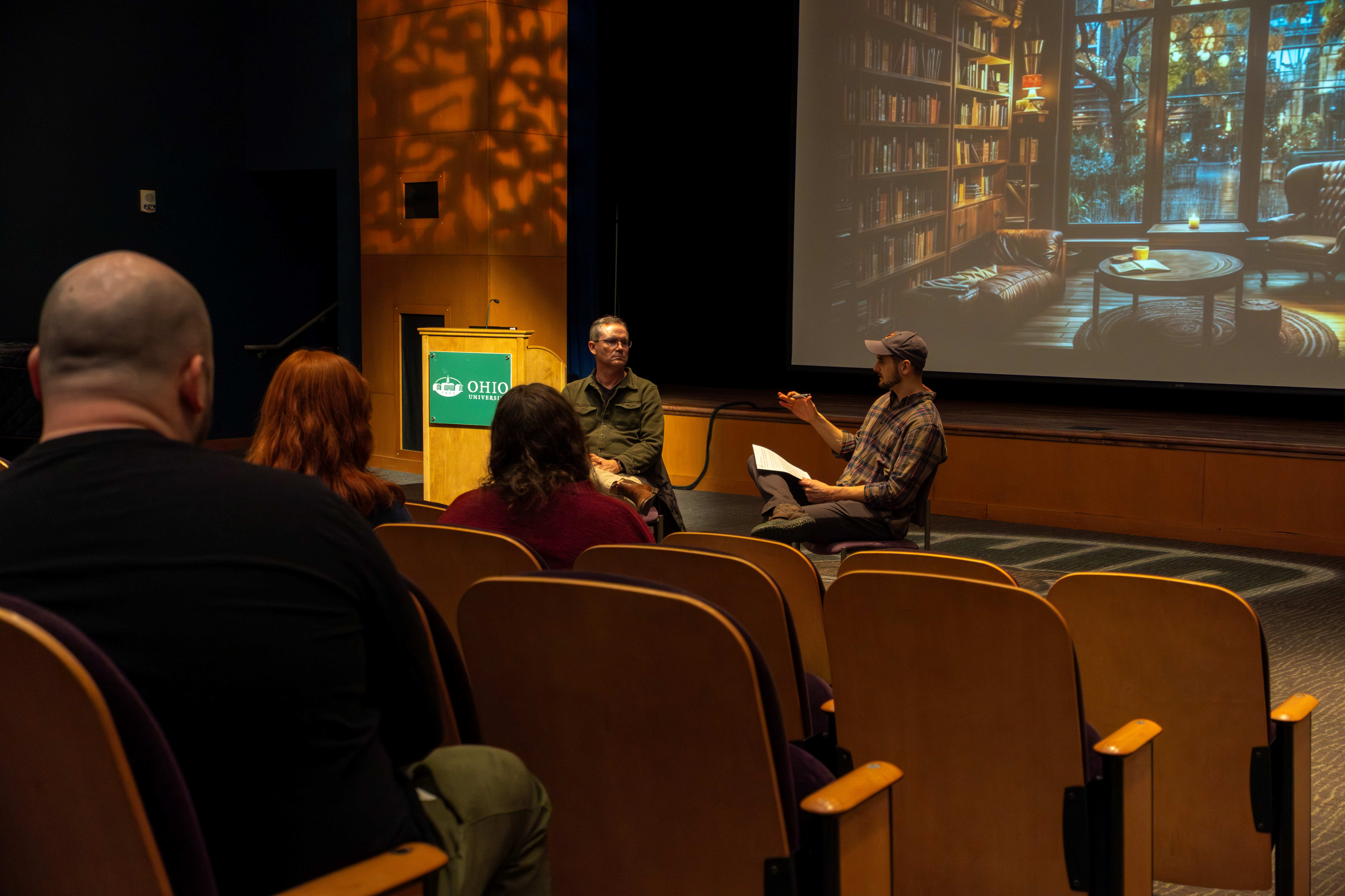 EIR Robb Roby talking with an interviewer at the front of a lecture hall during his "No Straight Line to Success" Fireside chat