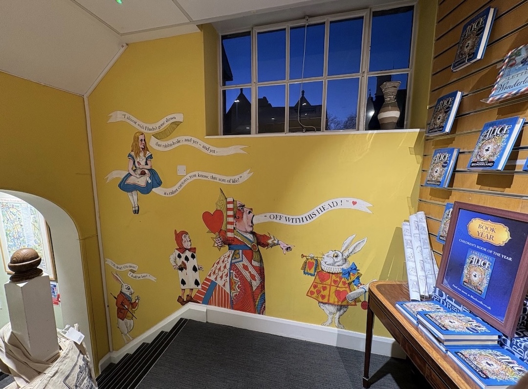 A wall of a book store featuring Alice in Wonderland characters including the Red Queen and Alice