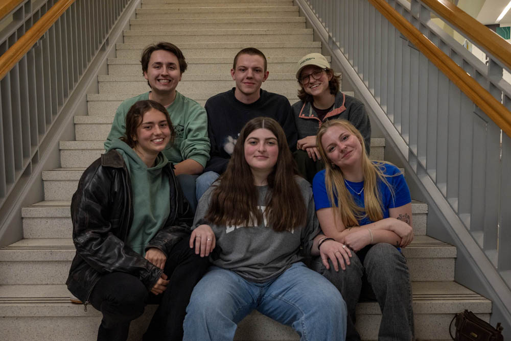 People smiling at camera on a staircase