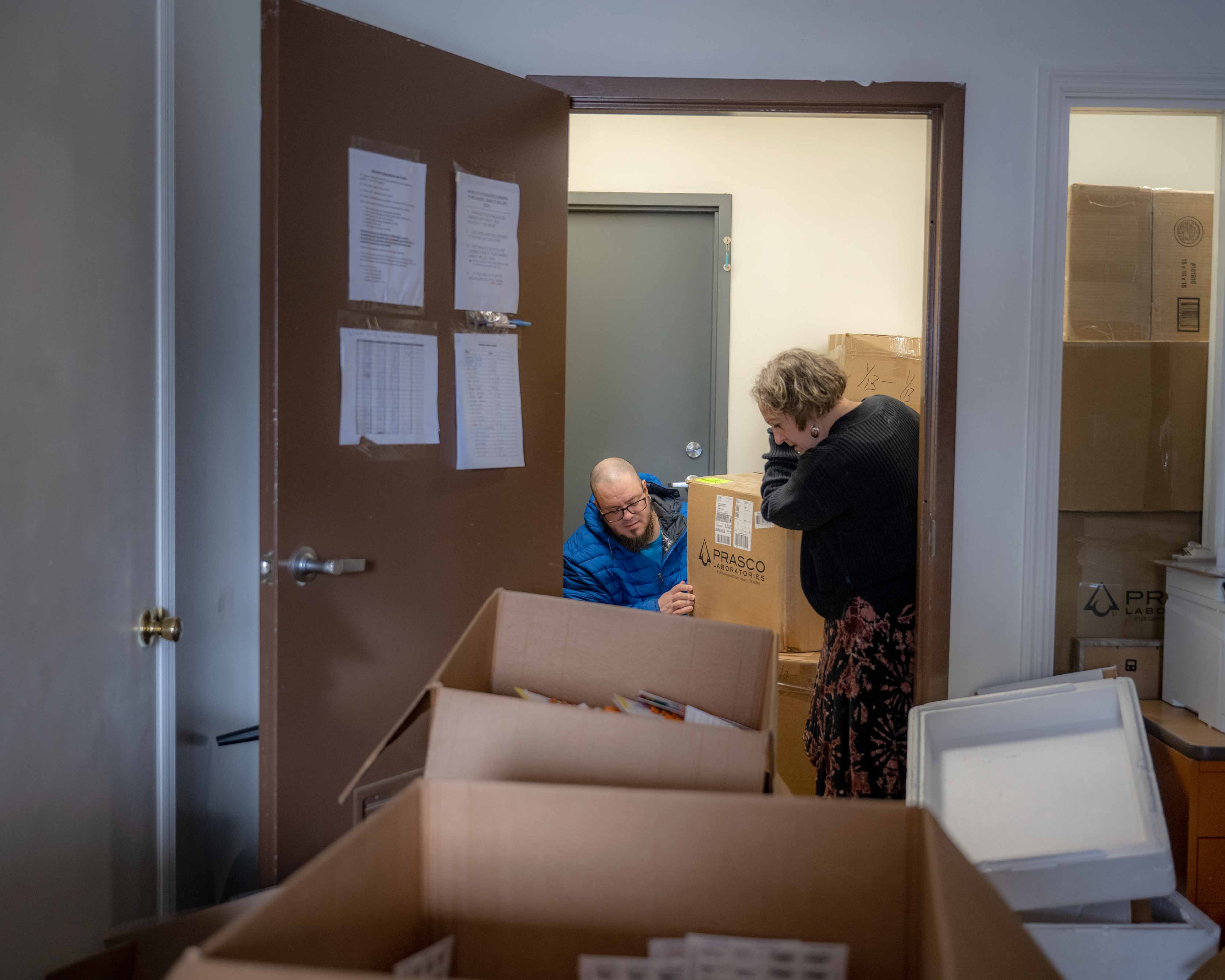 Dan Hughes and Sarah Adkins organize boxes of phataceuticals that have been donated to the pharmacy