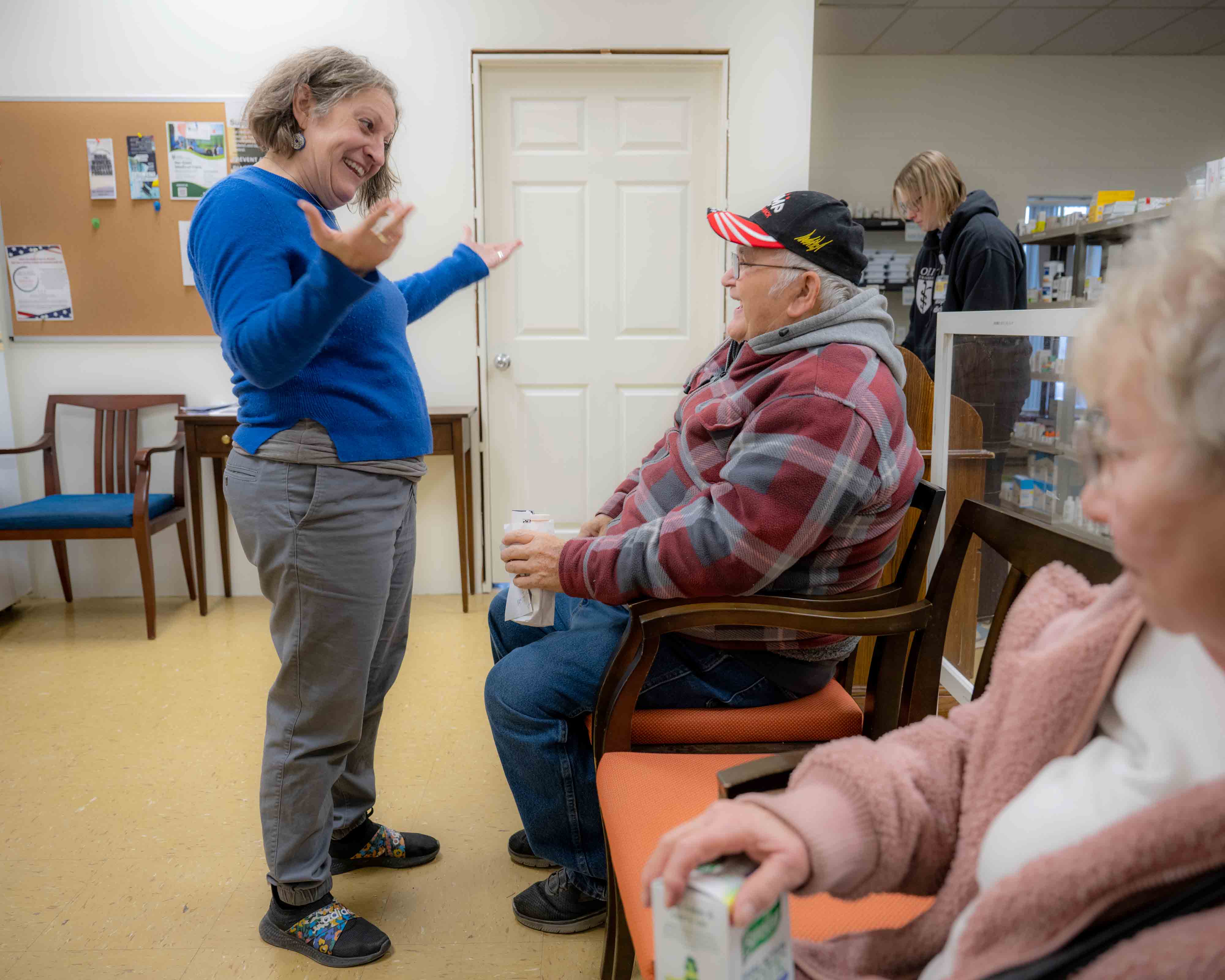 Sarah Adkins talks with people in the waiting room of Rising Suns Pharmacy