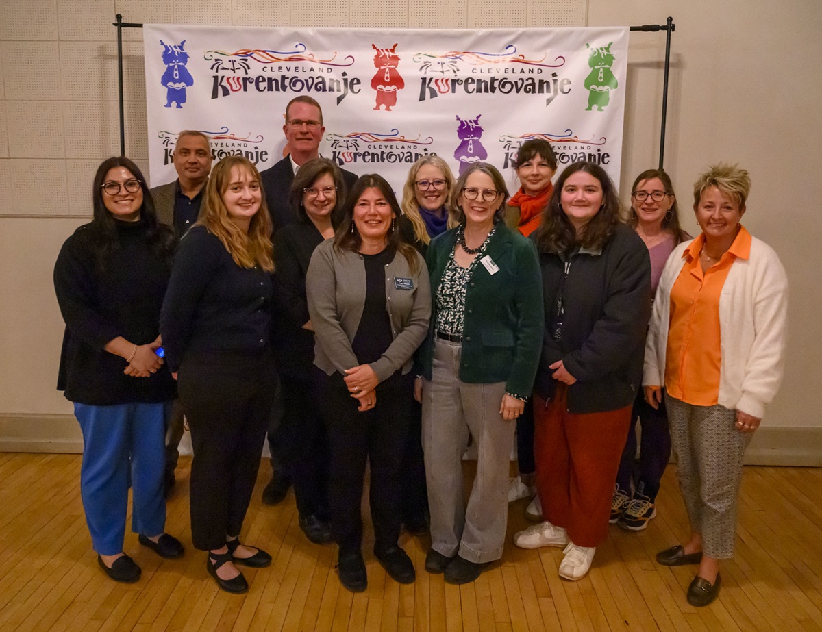 Representatives from the Voinovich School for Leadership and Public Service stand together in front of a banner