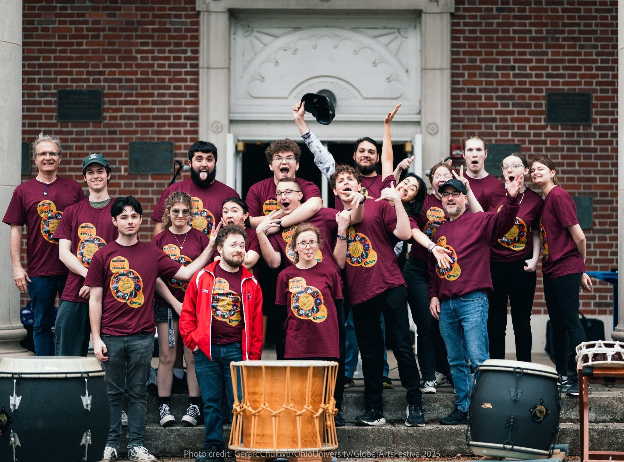 The Ohio U Percussion club standing together with large taiko drums in front of them. 