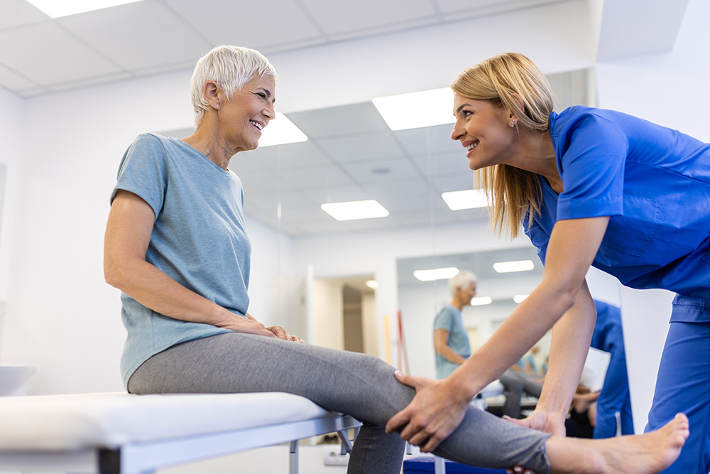 PA with older lady doing exercises in the clinic