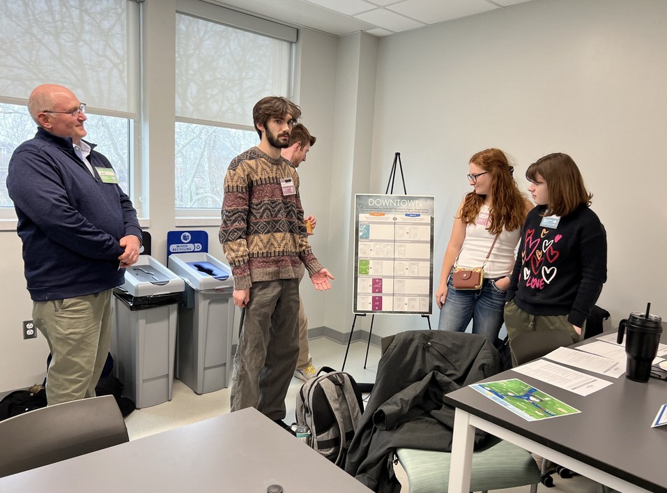 People standing in a classroom setting, discussing.
