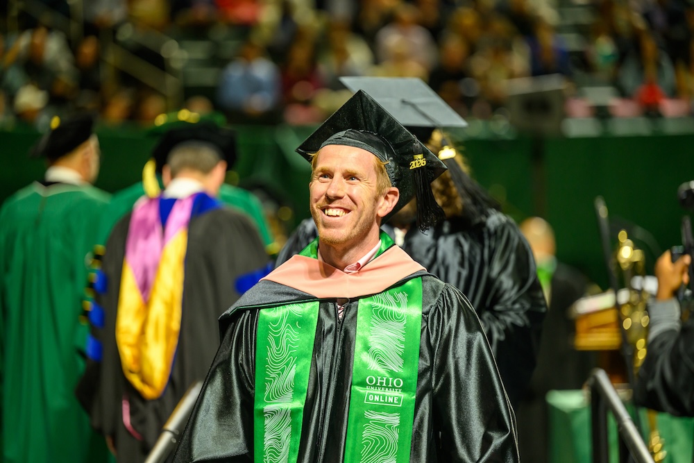 A student smiles after receiving a diploma at the spring 2026 graduate Commencement ceremony