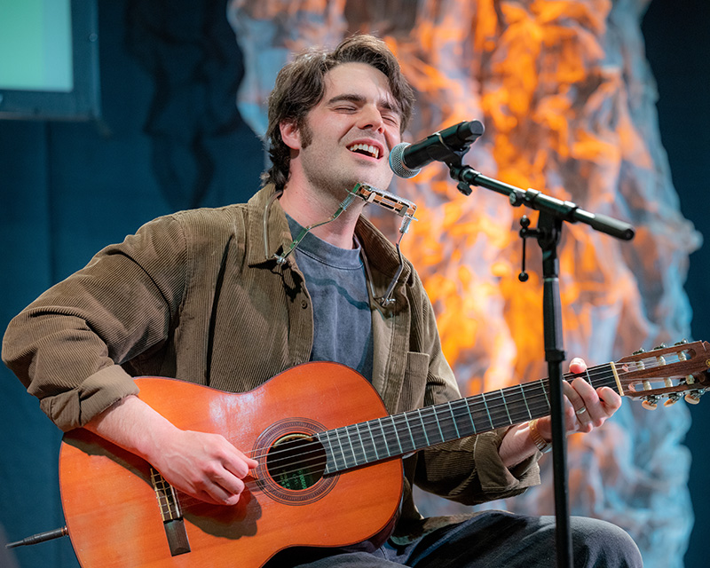 Jake Ewald sings and plays acoustic guitar during his keynote conversation in Baker Ballroom.