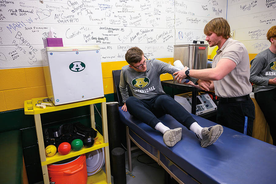 Athletic training alumnus Carter Luckring, MS ’24, works with a student athlete at Athens High School