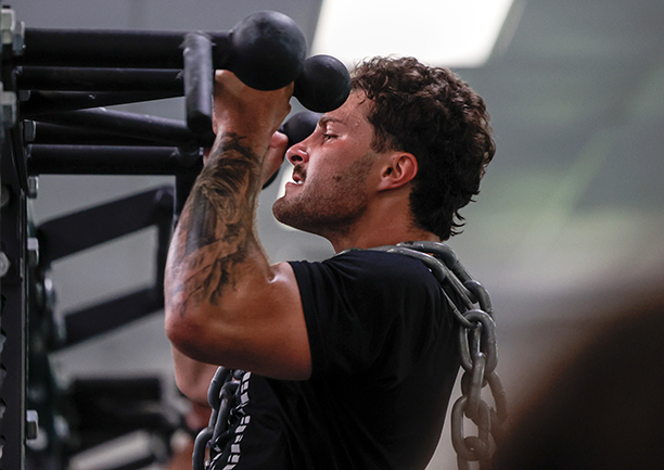Linebacker Charlie Christopher lifts weights during an indoor OHIO football strength training session.