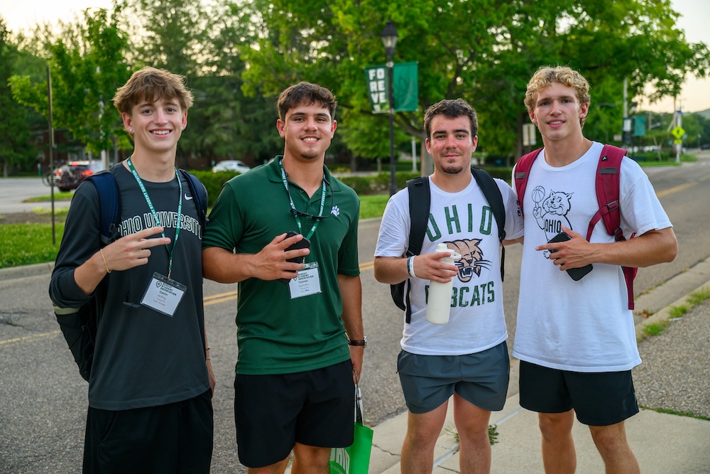 Four students stand together, smiling 