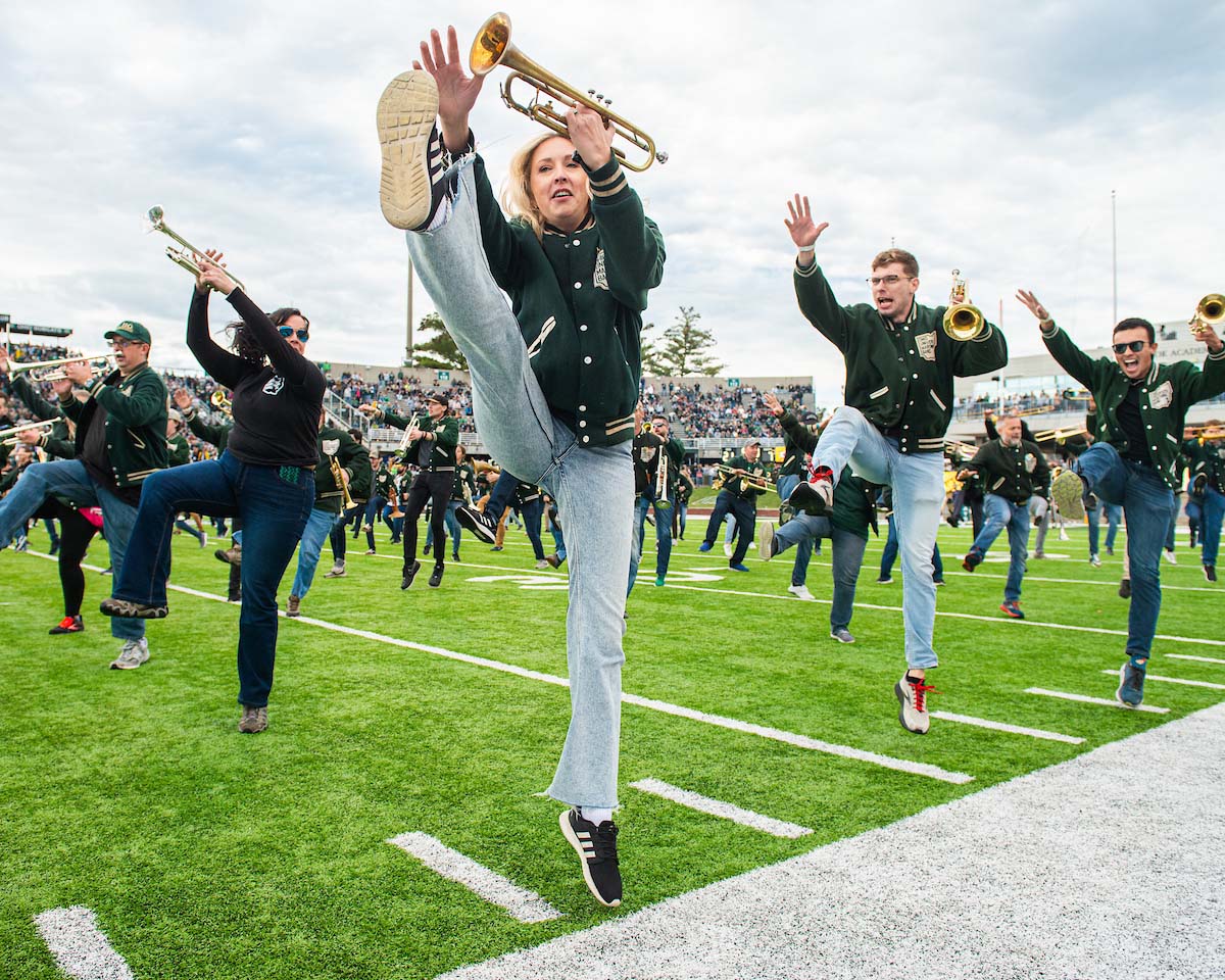 The Marching 110 Alumni Band performs on the field at Peden Stadium.