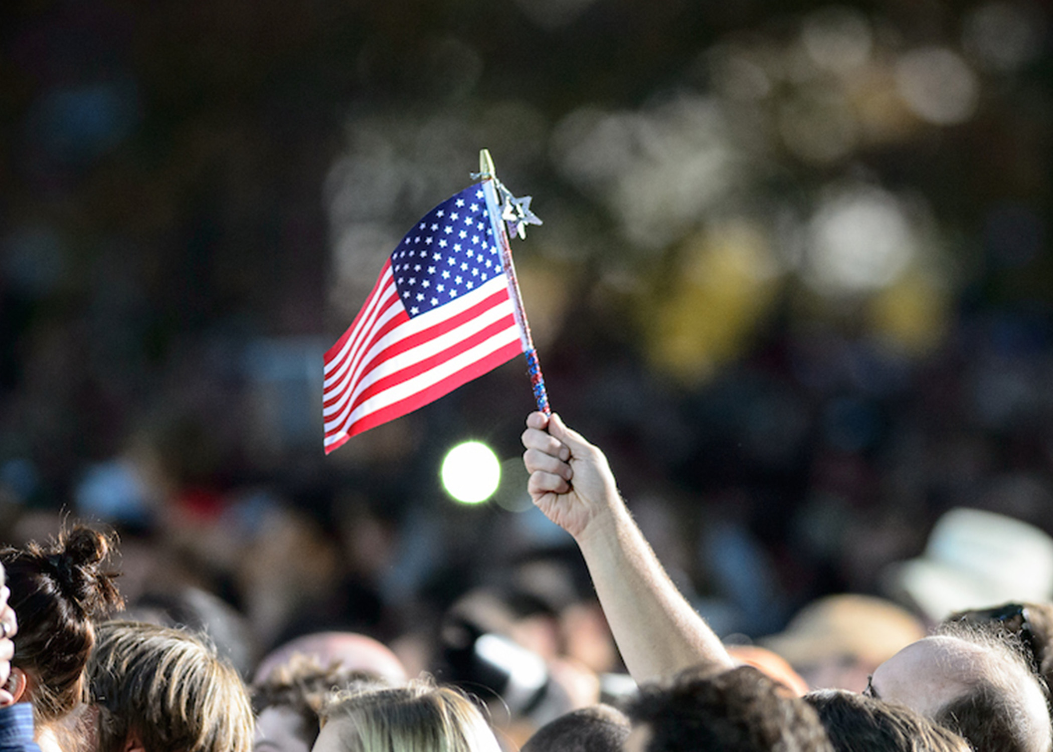 An American flag is waved amid a crowd