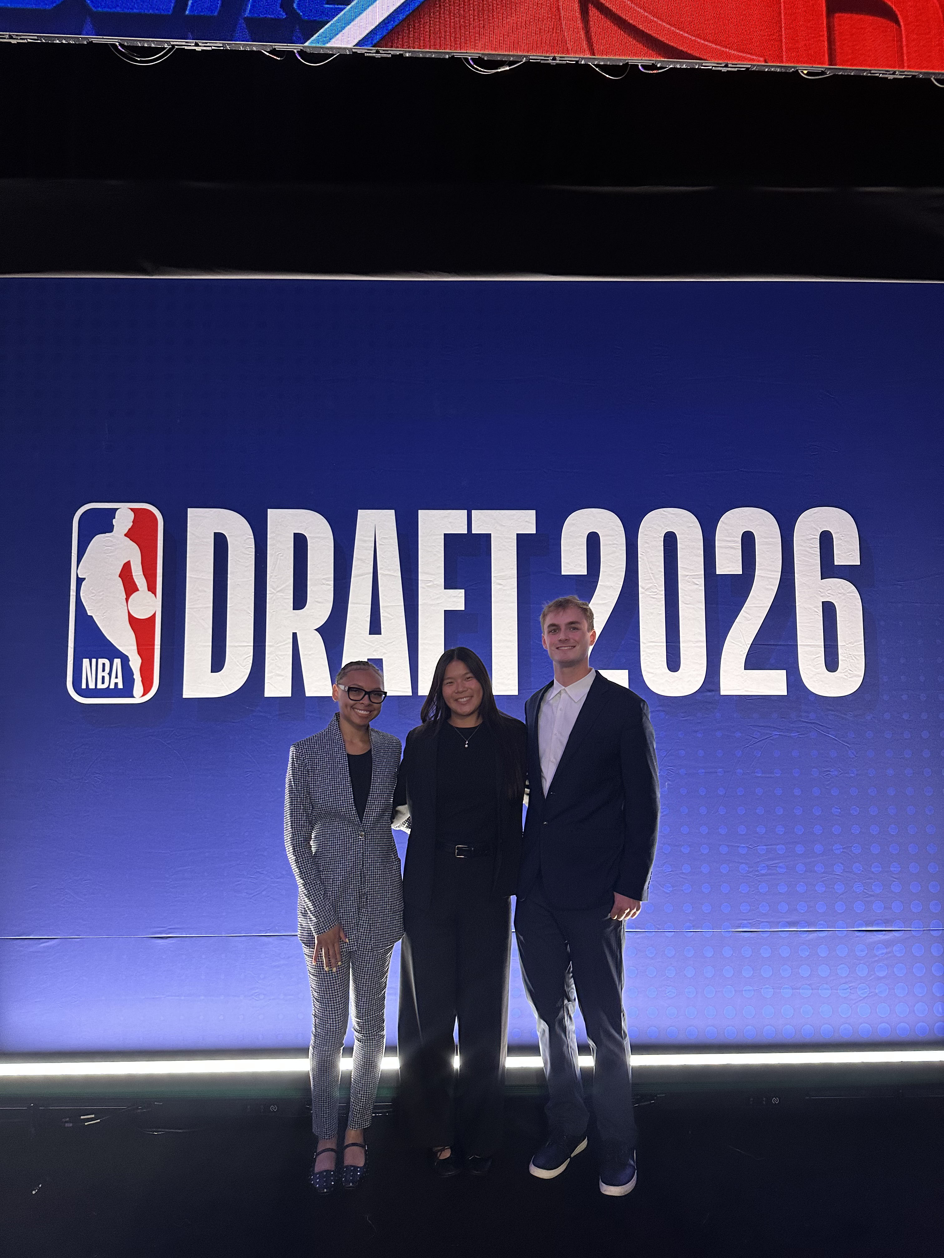 Quinn Elfers and collegues standing in front of a sign for the NBA Draft 2026.