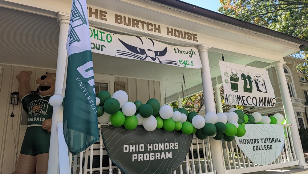 The outside of the Burtch House is decorated with a Rufus balloon, OHIO flag, green and white balloons and Homecoming signs