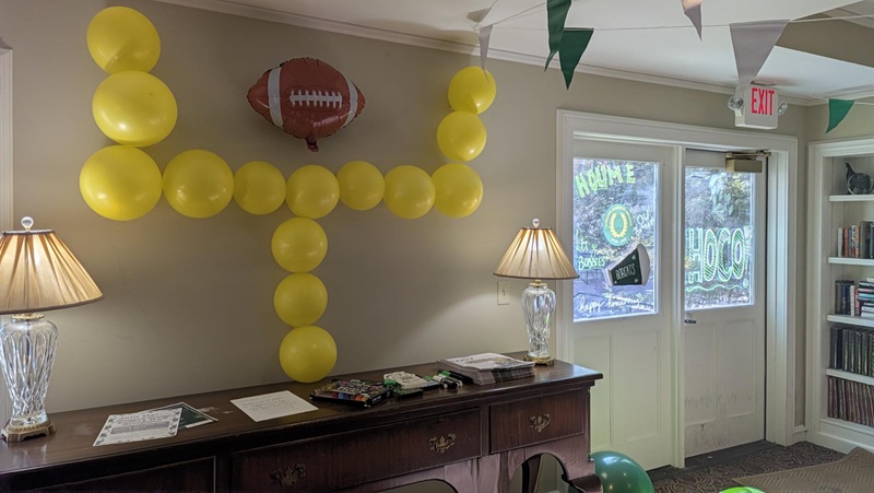 Ballons are decorated to look like a football goalpost, while a football is on the wall and the room has green and white decorations