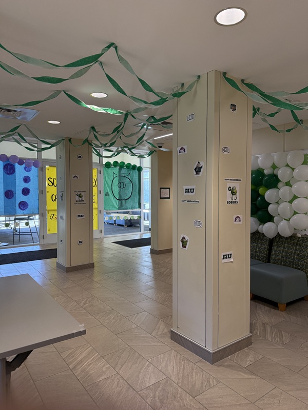 A  room inside Carr-Sowle is decorated with green and white balloons and streamers, as well as Homecoming signs
