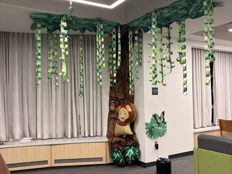 A room inside Ryors Hall is decorated with green and white decorations and an animal balloon