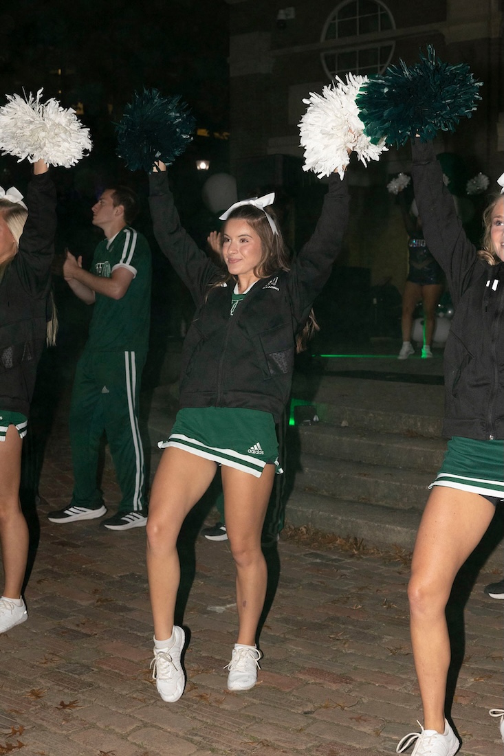 Cheerleaders raise their arms during the Yell Like Hell rally
