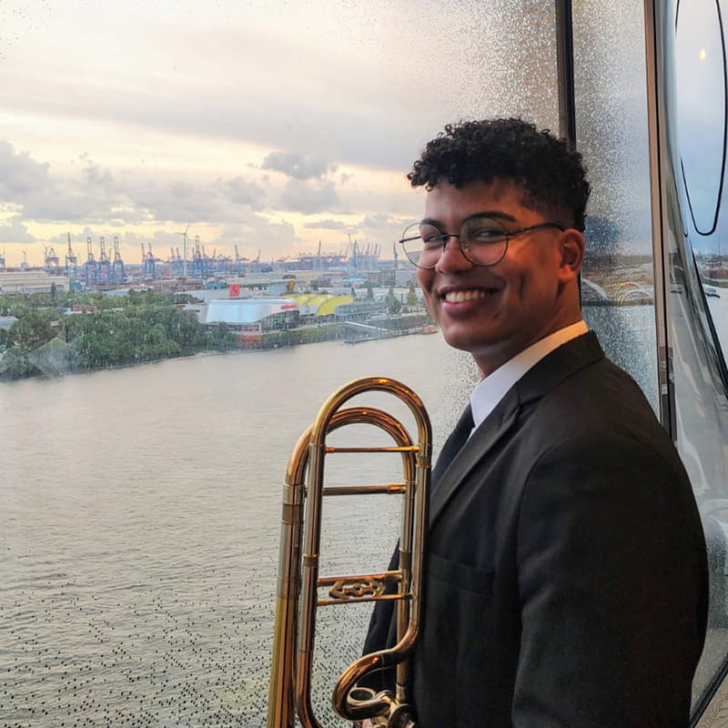 Harnefer Olveira Cruz with his trombone overlooking the ocean