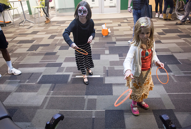 Ella Nielsen-Tucker, 8, (left) and Genevieve Nielsen-Tucker, 6, play ring toss during tRAC-or-Treat in James Hall on Oct. 24.