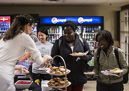 Selena Baker, the nutrition counselor for WellWorks, helps to serve a holiday feast to the international students in the College of Health Sciences and Professions during last year’s International Student Thanksgiving Dinner.