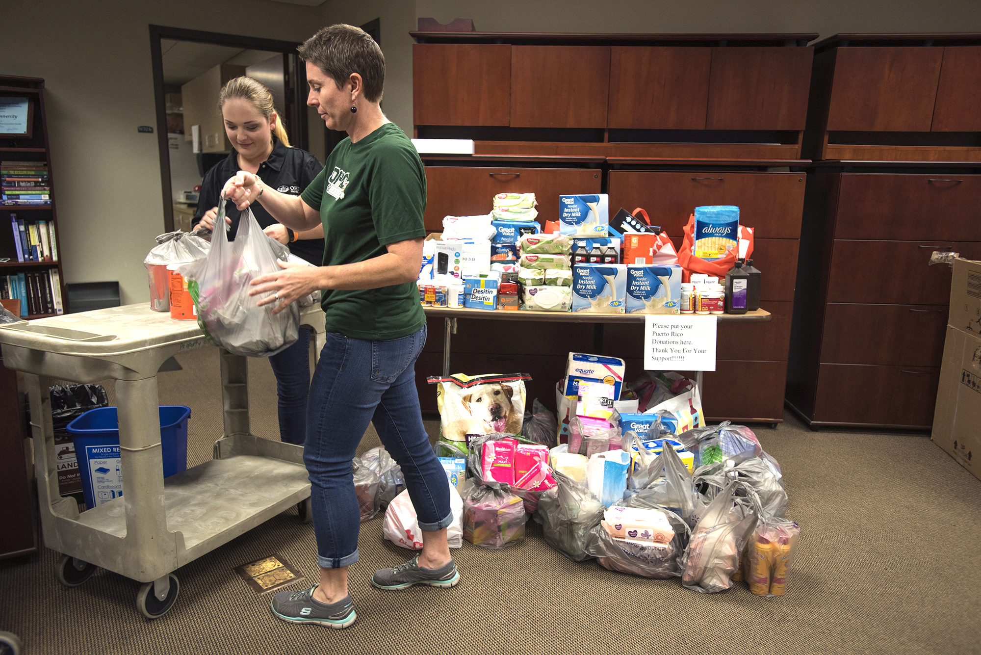 The OHIO College of Health Sciences and Professions’ Department of Social and Public Health chair Tania Basta and SPH administrative specialist Lindsay Radomski loaded carts to transport the donations from the office to Ohio University’s airport.