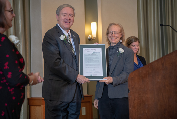 Ohio University President M. Duane Nellis presents a 2018 Outstanding Administrator Award to Faith Beale Knutsen, director of social innovation and entrepreneurship at the Voinovich School of Leadership and Public Affairs.