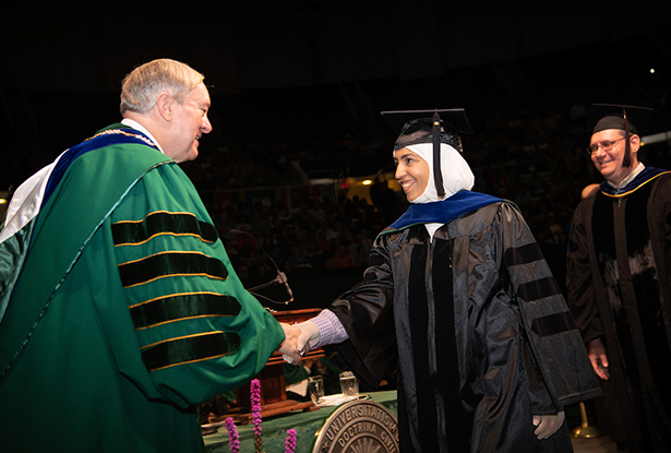 President Nellis congratulates Shrouq Hassan Aleithan on receiving a doctoral degree in physics.