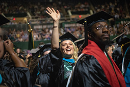 Student waves during Graduate Commencement