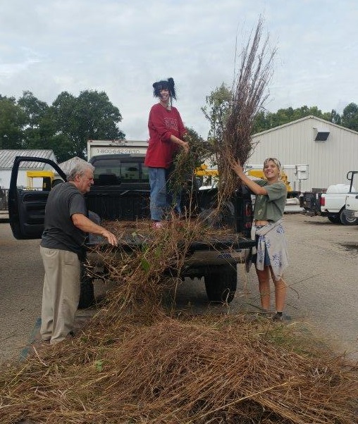 Students unload native grasses