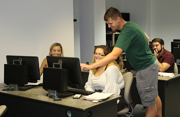 Jacob Sevens, Student Assistant for Recruiting, helps students add classes to their fall 2018 class schedule during orientation