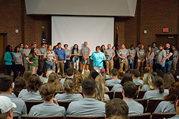Stephanie Burcham, director of development, led the new students in Stand Up and Cheer.