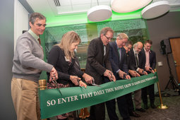 Speakers and other stakeholders made their way to the front of the room to take part in the ribbon cutting ceremony. Each was given a pair of scissors and together they officially reopened Ellis Hall by cutting a green banner.