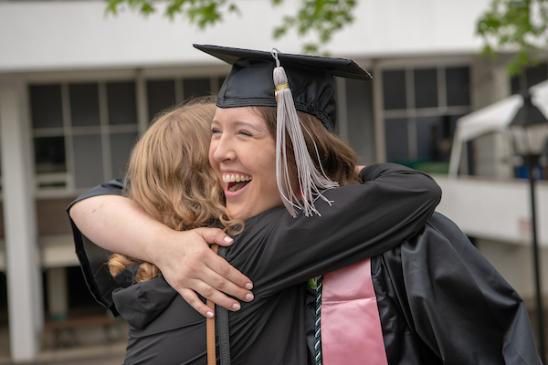 Abbey Phillips hugs friends following undergraduate commencement.