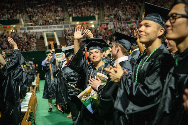 Trent Comfort (Center) waves to supporters art undergraduate commencement. 