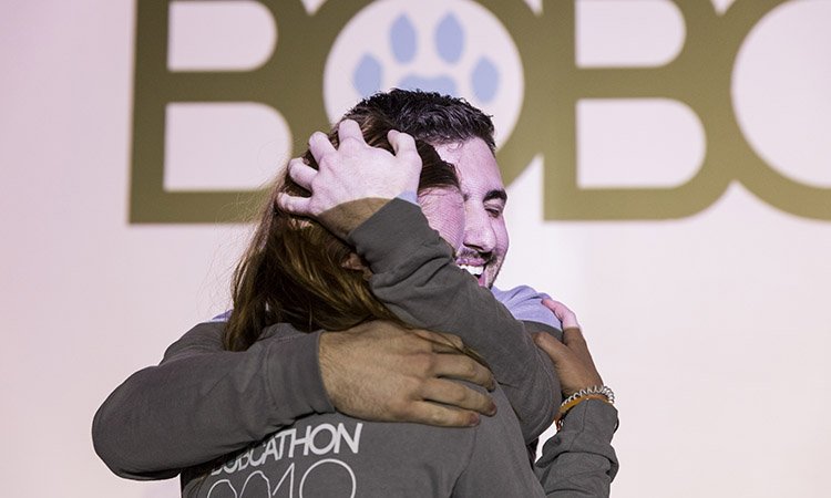 Ryan Capal, an Ohio University senior and director of branding and marketing for BobcaThon 2019, hugs a fellow member of the event’s leadership team after hearing the total raised during this year’s fundraising efforts. 