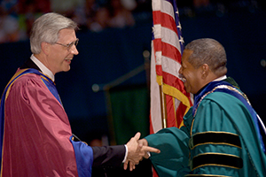 Pictured is a moment 35 years in the making for Ohio University alumnus Roderick J. McDavis, BSED ’70, as he shakes the hand of James Heap, past dean of the Patton College of Education, during OHIO’s 2005 Commencement ceremony. Dr. McDavis not only walked in that ceremony, 35 years after his class’ Commencement was canceled, but also presided over his first Commencement as president of the University. Photo courtesy of University Communications and Marketing