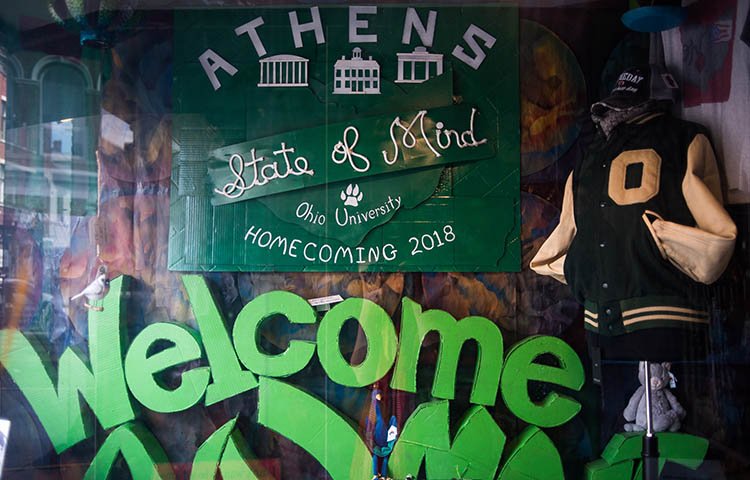 The window display at Mountain Laurel Gifts includes a replica of the Homecoming logo and a “Welcome Alumni” sign for Paint the Town Green.