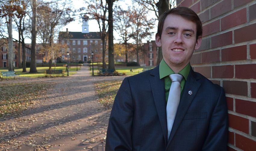 Mitchell “Mitch” Holland, BBA ’19, is pictured on Ohio University's College Green with Cutler Hall in the background.