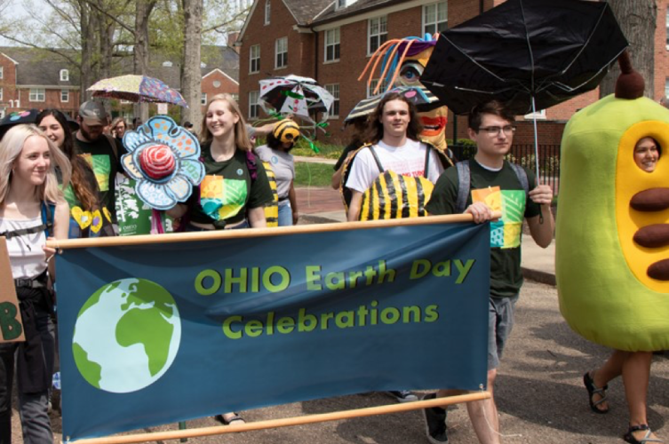 People walk in a parade celebrating Earth Day in 2019