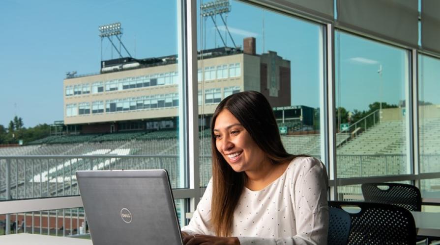 Girl working on laptop overlooking Peden Stadium