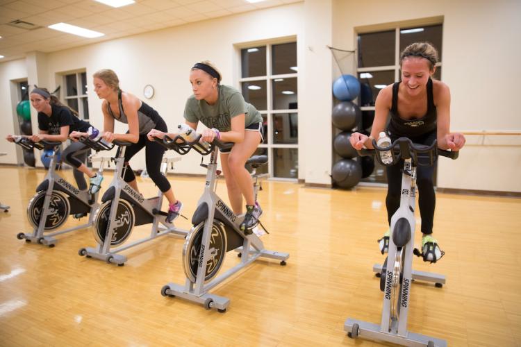 Four people in a spinning class