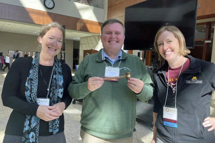 Larry Hayman, center, getting the MAPLA gavel at University of St. Thomas Law School in Minneapolis, with Martha Kirby, Immediate Past President, University of Iowa, left, and Erin Reichelt, President-Elect, University of Minnesota, right.